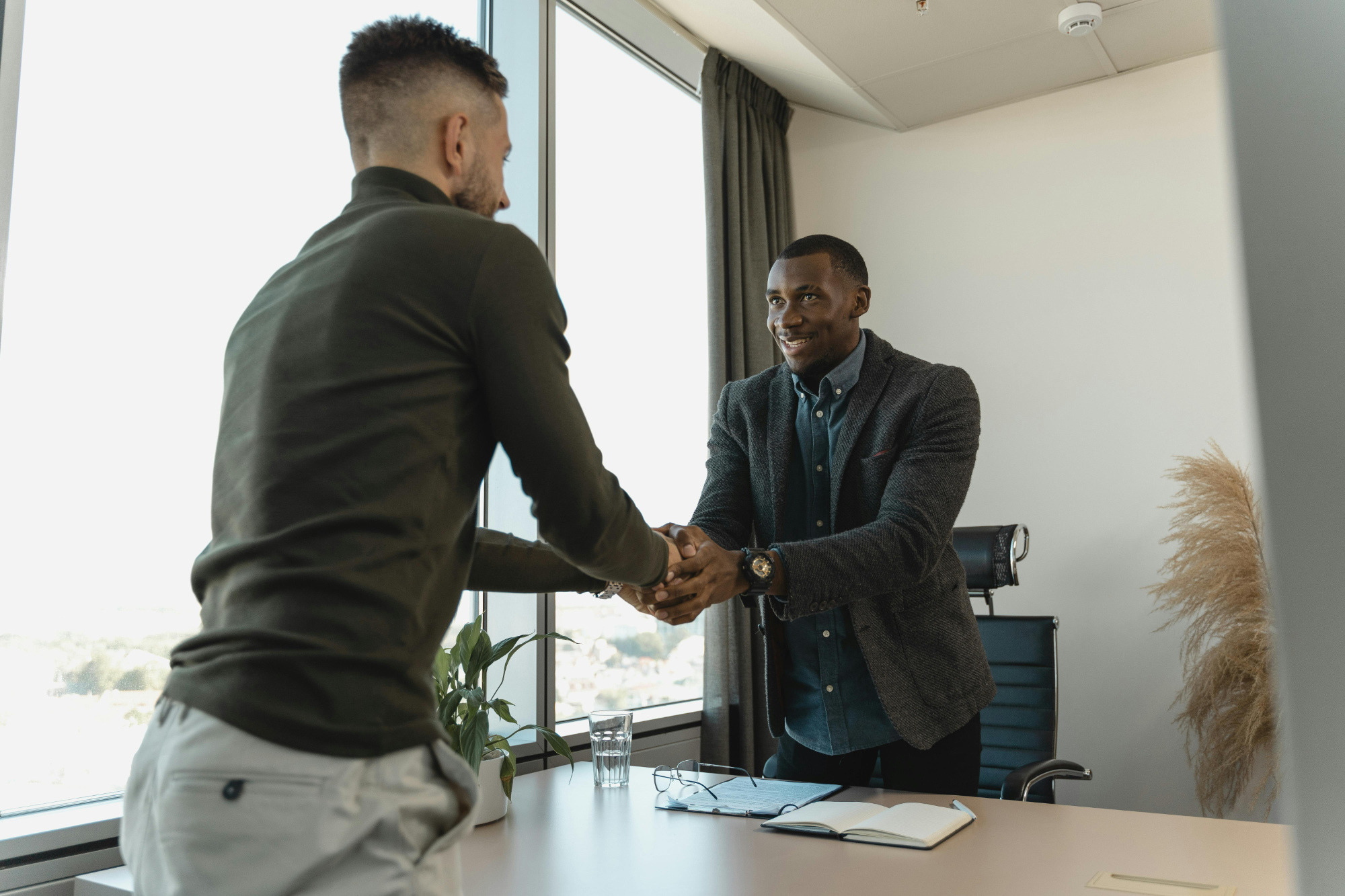 Boss and job candidate shaking hands after job interview.