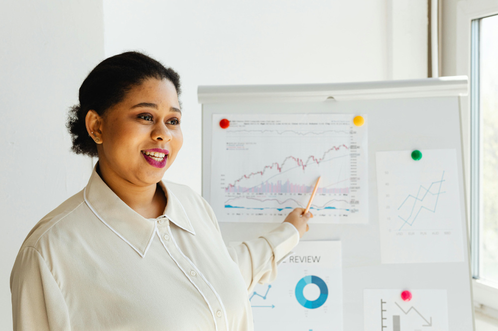 Office worker pointing backwards with pen at various business charts.